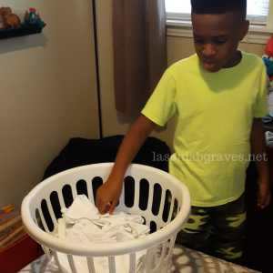 Young Black Boy Putting Away Laundry
